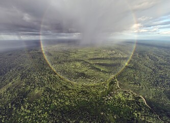 Rainbow over oil palm plantations and forest in Jambi
