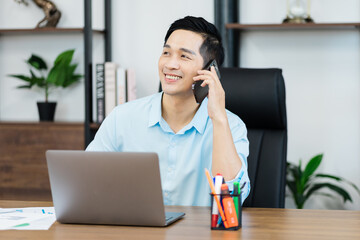 Asian businessman male portrait sitting at his desk