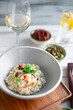 © Andrey - Risotto with crab meat and vegetables is served in a bowl. Dish with rice and seafood on table