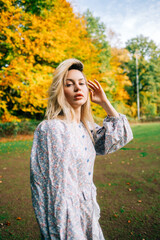 Wall Mural - Portrait of attractive caucasian woman posing in the autumn park.