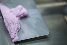 Decorator Using Spatula And Scraper Smoothing And Levelling Purple Lilac Buttercream Frosted Dark Chocolate Cake