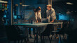 © Gorodenkoff - Small Creative Team Meeting in the Evening in Office. Young Project Manager Bringing Documents that They Check and Discuss Together with the Head of Department. Footage.