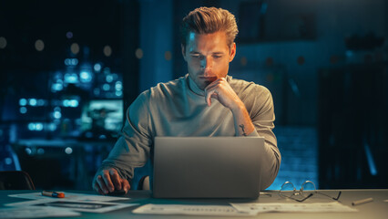 Poster - Handsome Man Working on Laptop Computer in a Company Office at Night. Young Specialist Analyzing Reports. Marketing Assistant Developing a Consumer Sales Strategy for a Client.