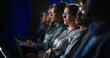 © Gorodenkoff - Young Psychologist Attending an International Cognitive Behavioral Therapy Seminar. Specialist Using Laptop Computer. Psychotherapy Professional Sitting in a Crowded Room on a Training Program.