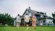 © Gorodenkoff - Real Estate Agent Showing a Beautiful Big House to a Young Successful Couple. People Standing Outside on a Warm Day on a Lawn, Talking with Businesswoman, Discussing Buying a New Home.