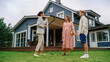 © Gorodenkoff - Professional Realtor Showing a Hot Property Location to a Young Successful Couple. Female Real Estate Agent with Tablet Walking with Family to the House. New Homeowners. Slow Motion
