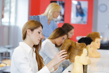 student cosmetologist working with dummy