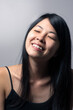 Japanese woman smiling with eyes closed and tilting head