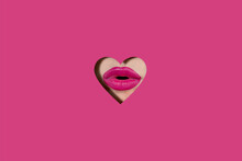A Girl With Beautiful Plump Lips, Painted Pink Lipstick. Lips In A Hole In The Form Of A Heart Made Of Viva Magenta Paper. Fashion, Beauty, Makeup, Cosmetics, Beauty Salon, Styl