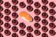 Sushi and Christmas balls pattern. Festive salmon sashimi nigiri and red balls on pink background. New Year holidays celebration. Creative Japanese food. Restaurant menu. Seamless, harsh light