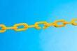 © xy - Yellow plastic chain on blue background