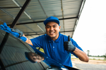 Wall Mural - Man worker washing car service with micro fiber. Car wash cleaning wipe station. Employees clean a vehicle professionally detailing.