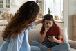 © DimaBerlin - Supportive mother comforting sad teenage girl rejected by friends, helping depressed teen daughter to deal with breakup. Upset depressed adolescent child looking at phone at home, waiting for call