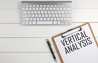 Poster - Home office workspace with keyboard, clipboard and pen with text VERTICAL ANALYSIS on white wooden background , business concept