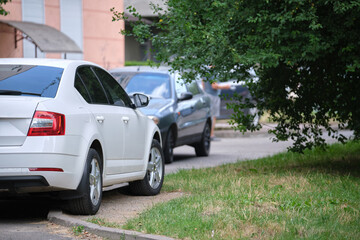 Wall Mural - Cars parked in line on city street side. Urban traffic concept