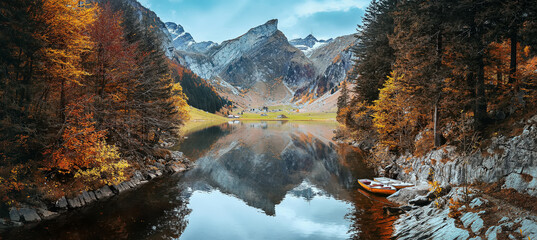 Fotobehang - Amazing autumn scenery of Swiss Alps. Incredible nature landscape. View on Santis peak, Seealpsee lake and colorful trees in autumn time. Awesome nature Background. Concept ideal resting place