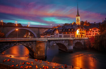 Fototapete - Wonderful vivid cityscape. Scenic view Historical Old Town of Bern city, bridges over Aare river and church tower during dramatic sunset. Bern. Switzerland. Europe