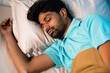 © WESTOCK - peacful young man sleeping during night - concept of relaxation, napping and wellness