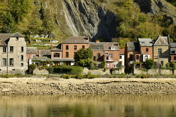 Façades arrières de maisons ouvrières traditionnelles longeant la Meuse au niveau très bas à Dinant 