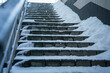 Wintery stone staircase covered with snow and ice layer outdoor. Slippery steps in winter season outside.