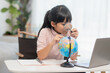 © FAMILY STOCK - Asian little girl is learning the globe model, concept of save the world and learn through play activity for kid education at home.