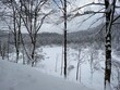 Der Wald im Sankenbachtal im Schwarzwald ist an diesem Wintertag tief verschneit. Unten liegt der Sankenbachsee. 