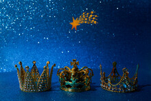 Three Crowns Of The Three Wise Men With Star Over Blue Background. For Reyes Magos Day And Happy Epiphany Day.