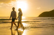 Romantic couple walking on beach during the sunset