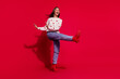 © deagreez - Full length photo of charming excited lady wear white sweater dancing walkign empty space isolated red color background