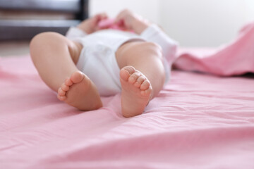 Canvas Print - Little baby lying on bed indoors, closeup