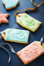 Close-up Of Festive Sugar Cookie Gift Tags Decorated In Pastel Colors On A Blue Background
