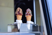Pair Of Chocolate Topped Soft Serve Ice Cream Waffle Cones In Ice Cream Van Window