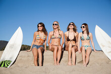 Young Women With Surfboards Sitting On Beach, Zuma Beach, California, USA