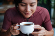 © Jonathan De Guzman - A young female cyclist having a cup of coffee at a cafe by the mountains.