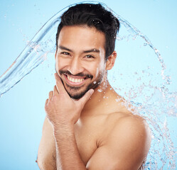 Wall Mural - Portrait, water and shower with a man model in studio on a blue background for hygiene or hydration. Face, beauty and skincare with a handsome young male wet from a water splash in the bathroom