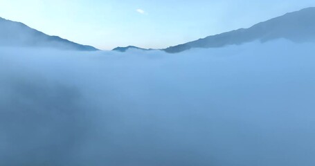 Wall Mural - sea of fog move flowing over mountain and sapan village in the valley, tourist attractions and important landmarks of Nan Province Northern Thailand, footage 4k video aerial drone point of view,