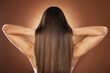 © J Bettencourt/peopleimages.com - Woman, back or hair style on brown background in relax studio for keratin treatment, self care wellness or color dye routine. Model, texture or brunette growth aesthetic with balayage transformation