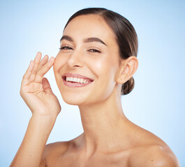 Portrait, skincare and beauty with a model woman in studio on a blue background for natural treatment. Face, wellness and luxury with an attractive young female posing to promote a skin care product