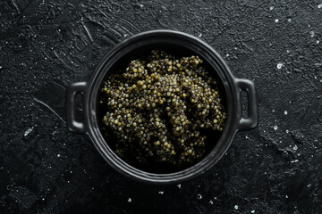 A jar with high-quality black caviar. Luxury food. On a concrete background.