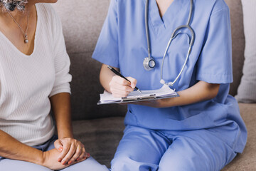 Homecare nursing service and elderly people cardiology healthcare. Close up of young hispanic female doctor nurse check mature caucasian man patient heartbeat using stethoscope during visit