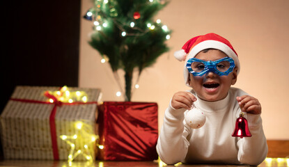 Wall Mural - child boy wearing santa cap, funny goggles 