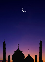 silhouette of mosques dome and crescent moon on dark blue twilight sky background in vertical frame,