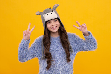 Fashion happy young woman in knitted hat and sweater having fun over colorful blue background. Happy face, positive and smiling emotions of teenager girl.