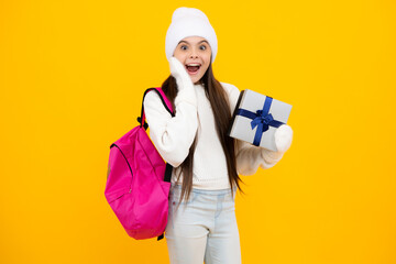 Excited face. Teenager child in winter wear holding gift boxes celebrating happy New Year or Christmas. Winter kids holiday. Amazed expression, cheerful and glad.