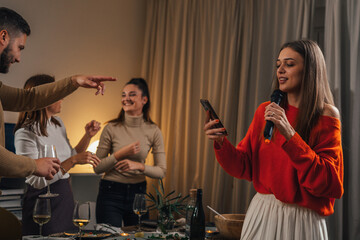 Wall Mural - Adult woman sings a song on karaoke night at a home party