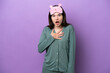 © luismolinero - Young Russian woman in pajamas isolated on purple background surprised and shocked while looking right