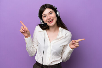 Wall Mural - Telemarketer Russian woman working with a headset isolated on purple background pointing finger to the laterals and happy