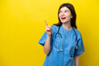 © luismolinero - Young surgeon doctor Russian woman isolated on yellow background intending to realizes the solution while lifting a finger up