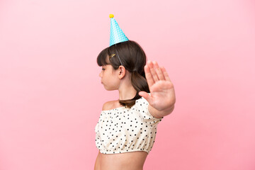 Canvas Print - Little caucasian kid with birthday hat isolated on pink background making stop gesture and disappointed