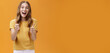 Excited girl expressed support and cheer raising thumbs up in approval and like gesture smiling optimistic and positive being amused with awesome idea standing pleased over orange background